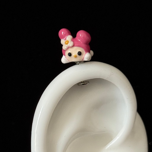 Small cartoon character on top of a white ear model against a black background